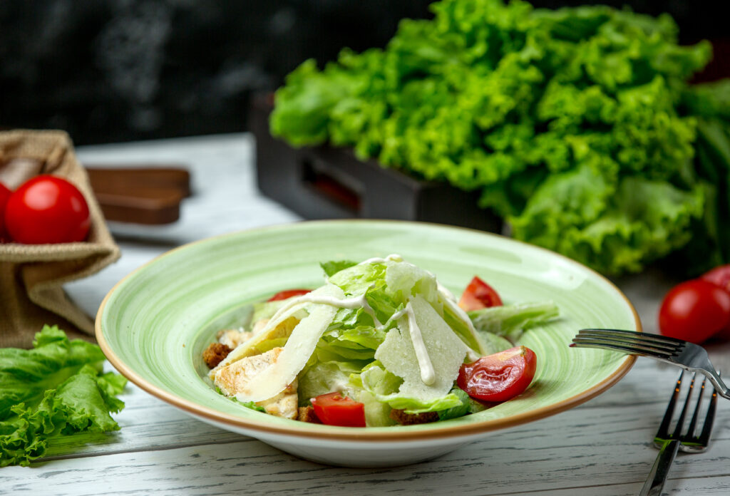 Sub in a Tub served in a clear bowl, featuring shredded lettuce, cucumbers, tomatoes, turkey slices, roast beef, chicken salami, red onions, banana peppers, feta cheese, and a drizzle of olive oil dressing, garnished with parsley.