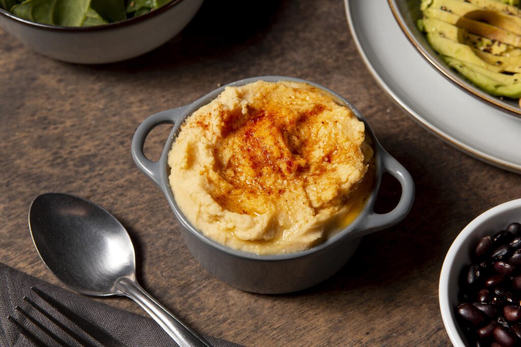 Twice baked mashed potatoes with a golden, crispy top and garnished with fresh chives on a white plate.