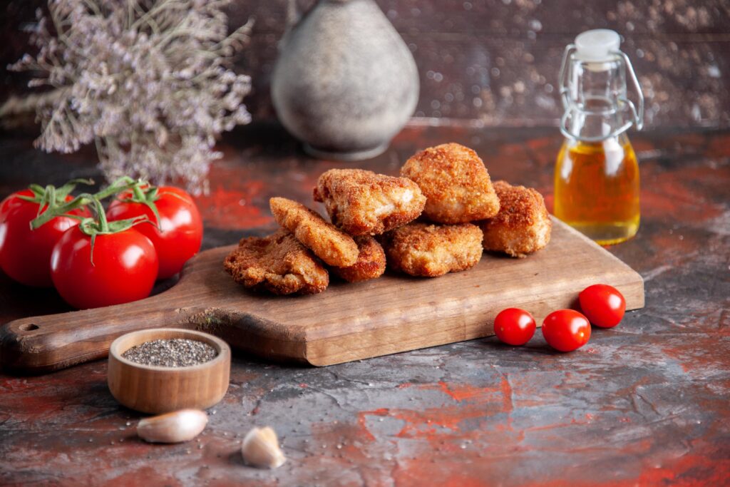 A plate of homemade Chick-fil-A grilled nuggets served with dipping sauces and a side of vegetables.